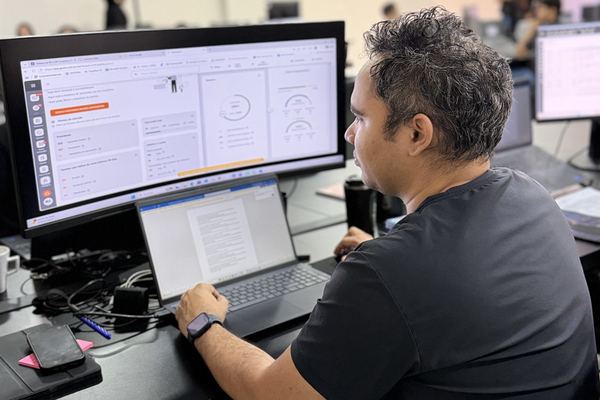 Analista da Contaxx analisando dashboards em monitor ultrawide
